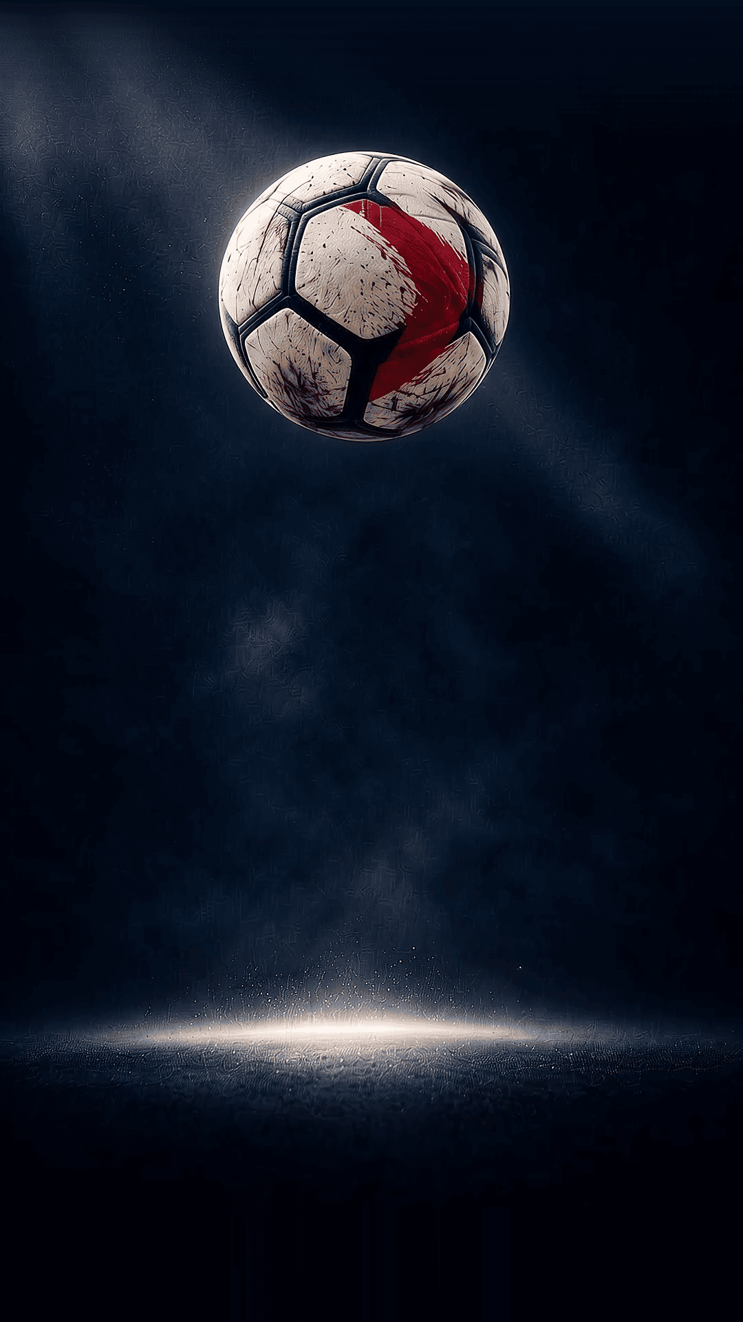 A match ball in mid-air under floodlights on a dark pitch