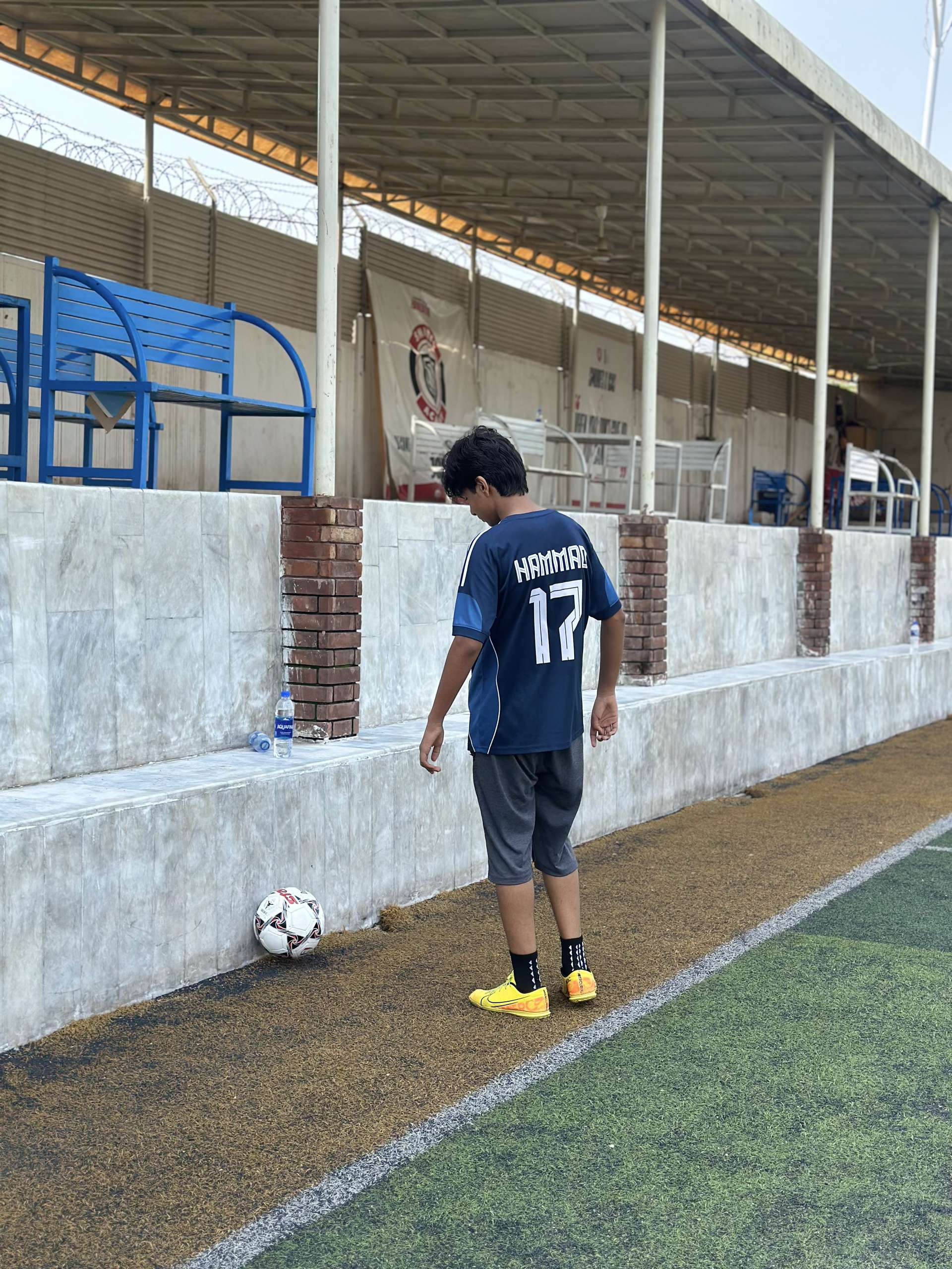 Number 17 waiting on the sideline with a ball at his feet