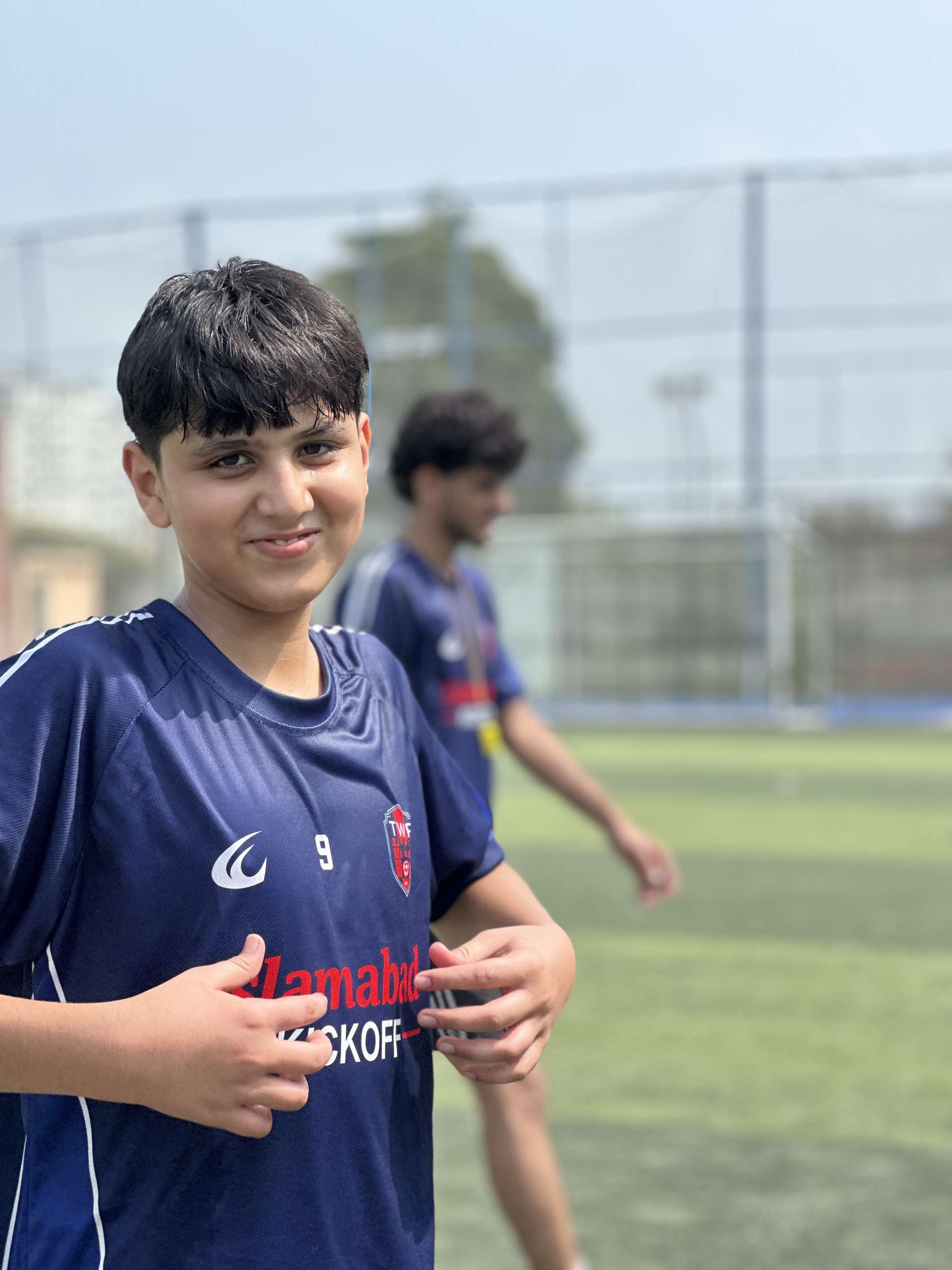 Number 9 grinning at the camera in the navy home shirt