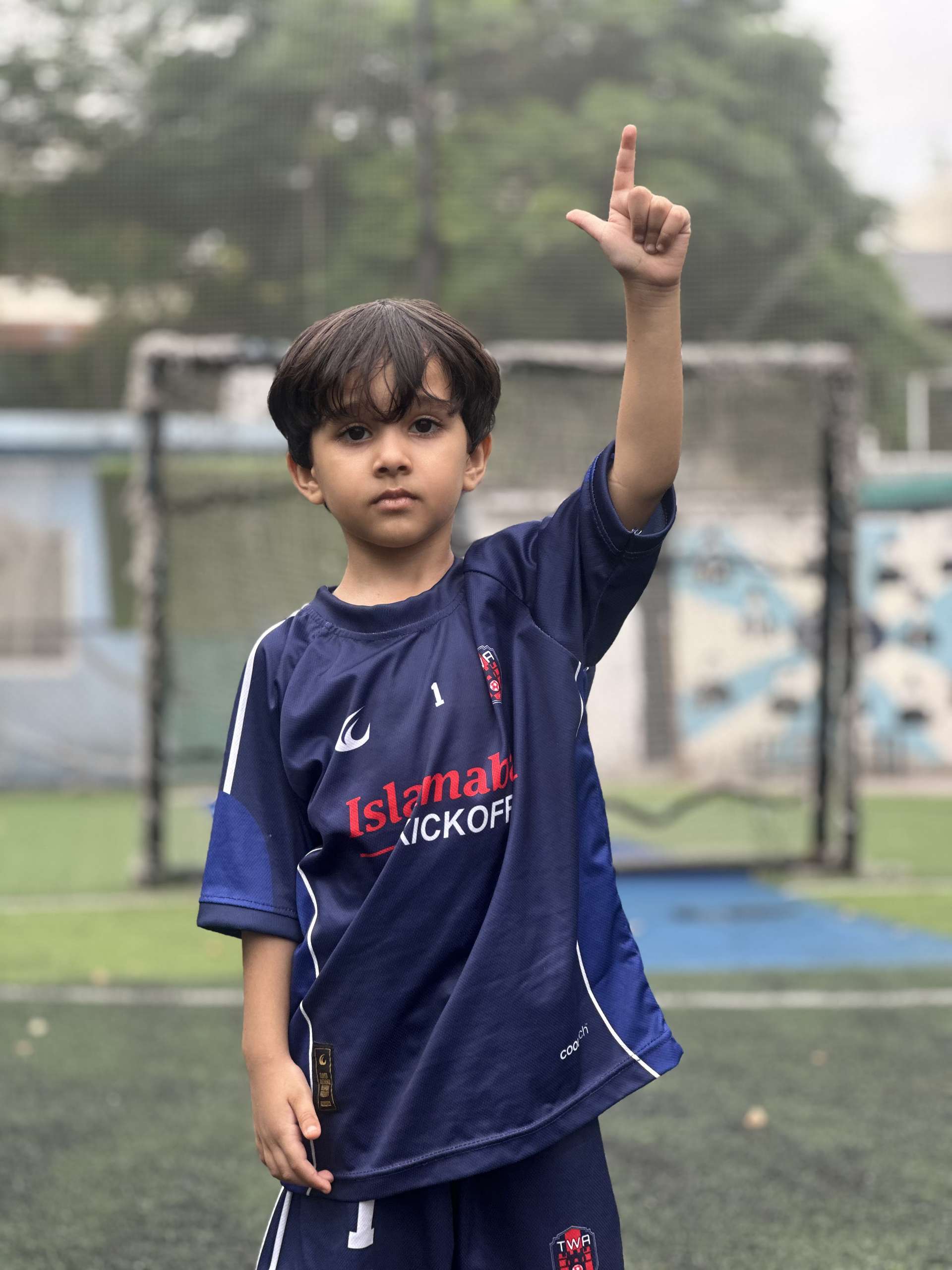 The youngest player holding one finger up to the camera