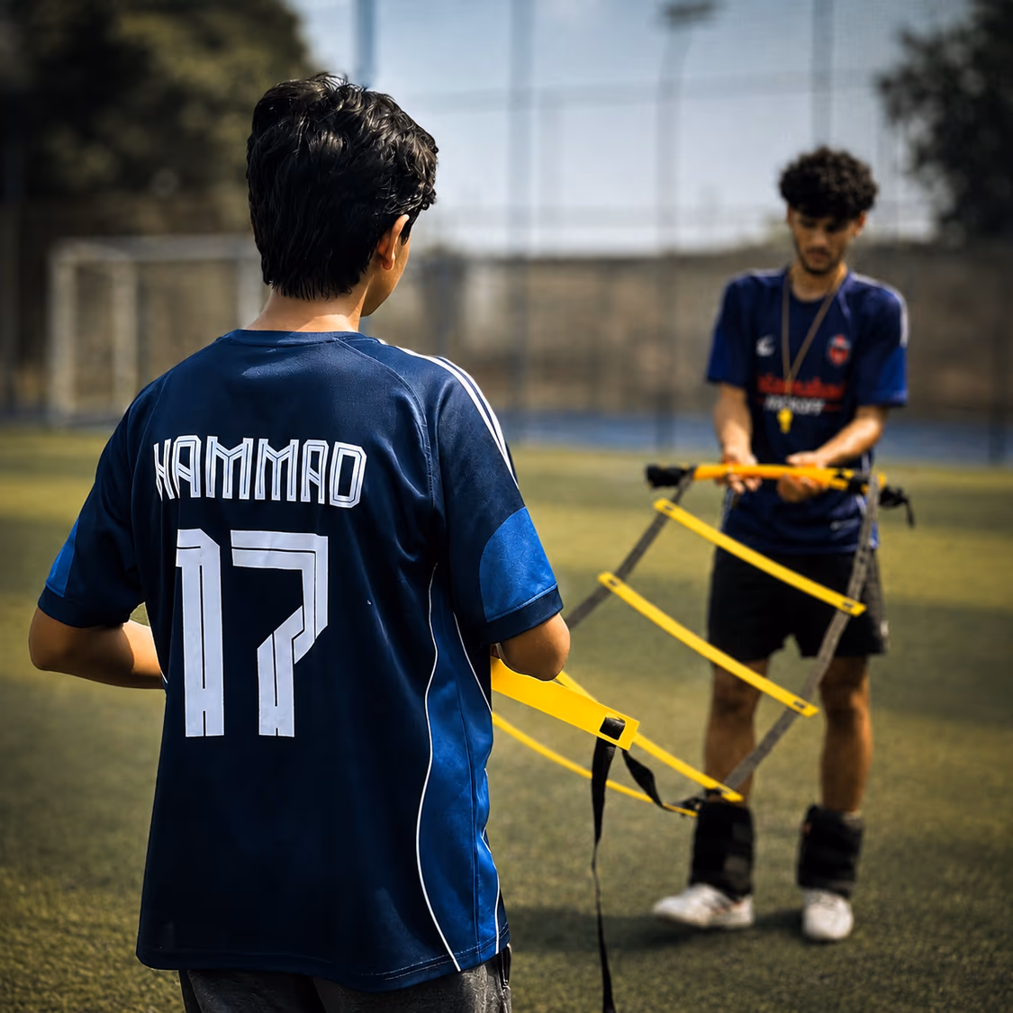 A coach running a TWA FC player through an agility ladder drill