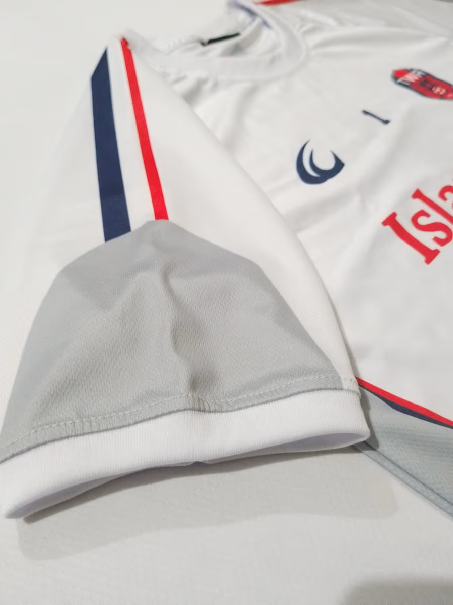 The contrast red and navy trim on the sleeve of the white away shirt