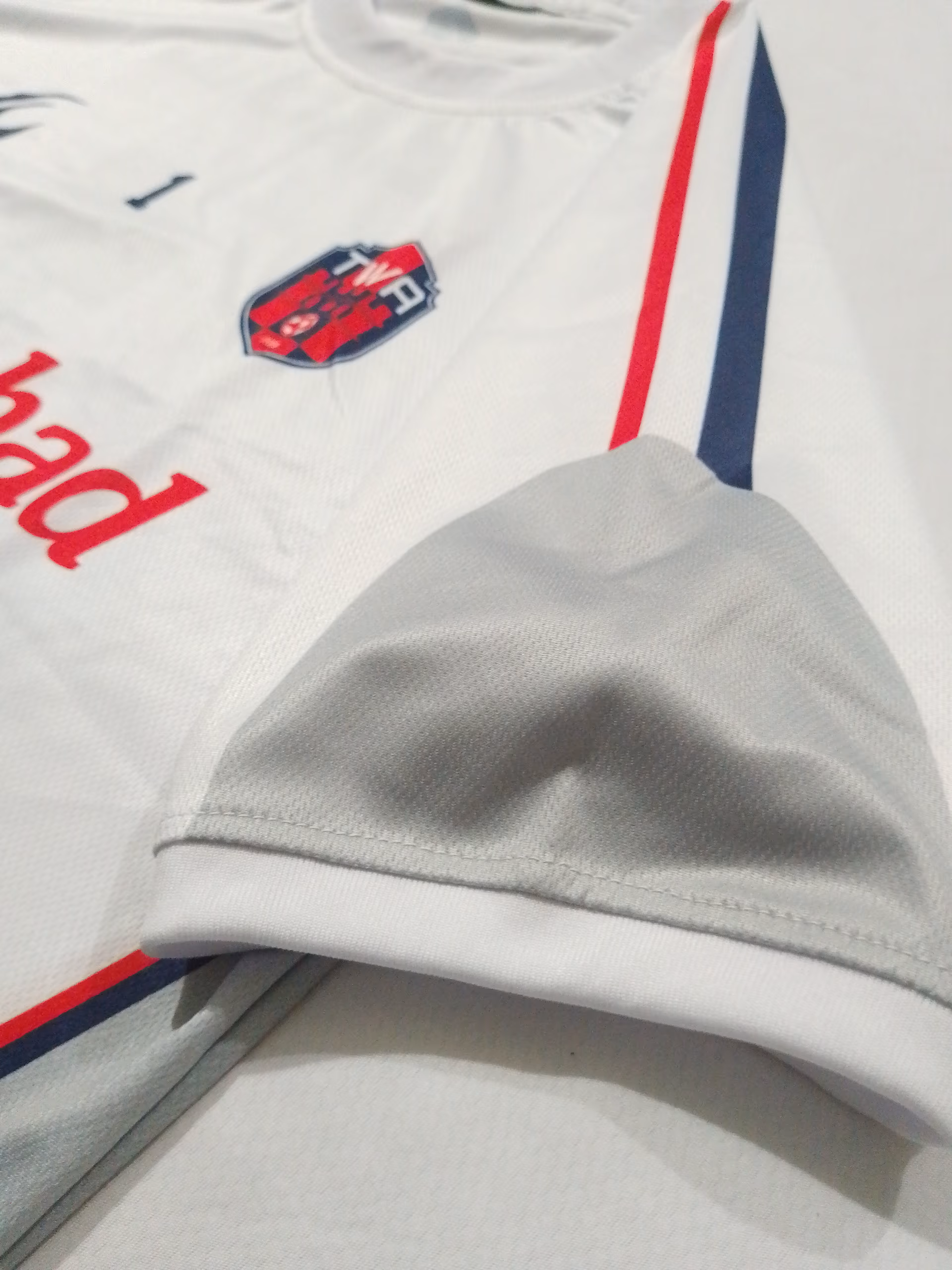 Macro shot of the contrast trim stitched into the white away shirt