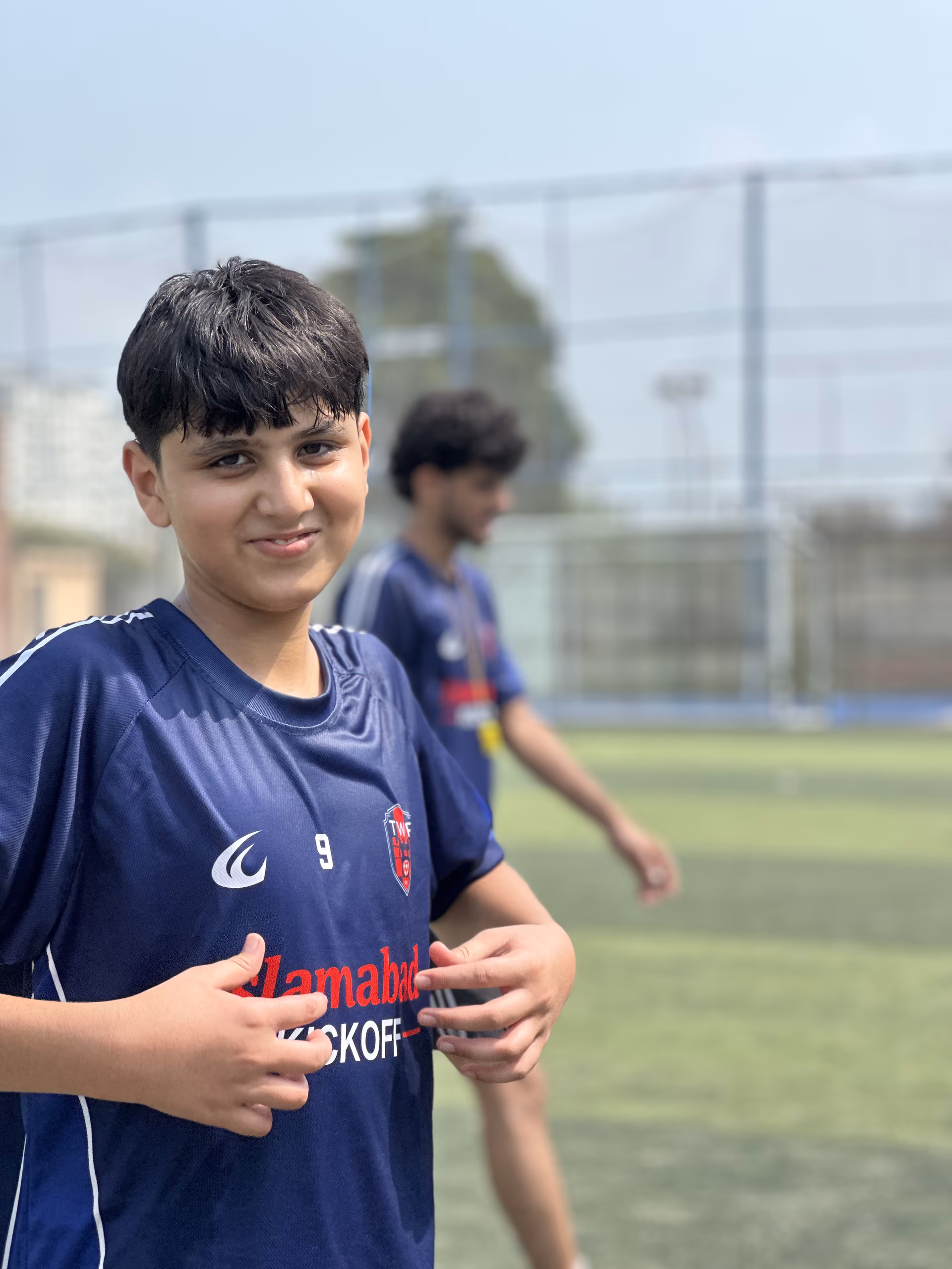 Number 9 grinning at the camera in the navy home shirt