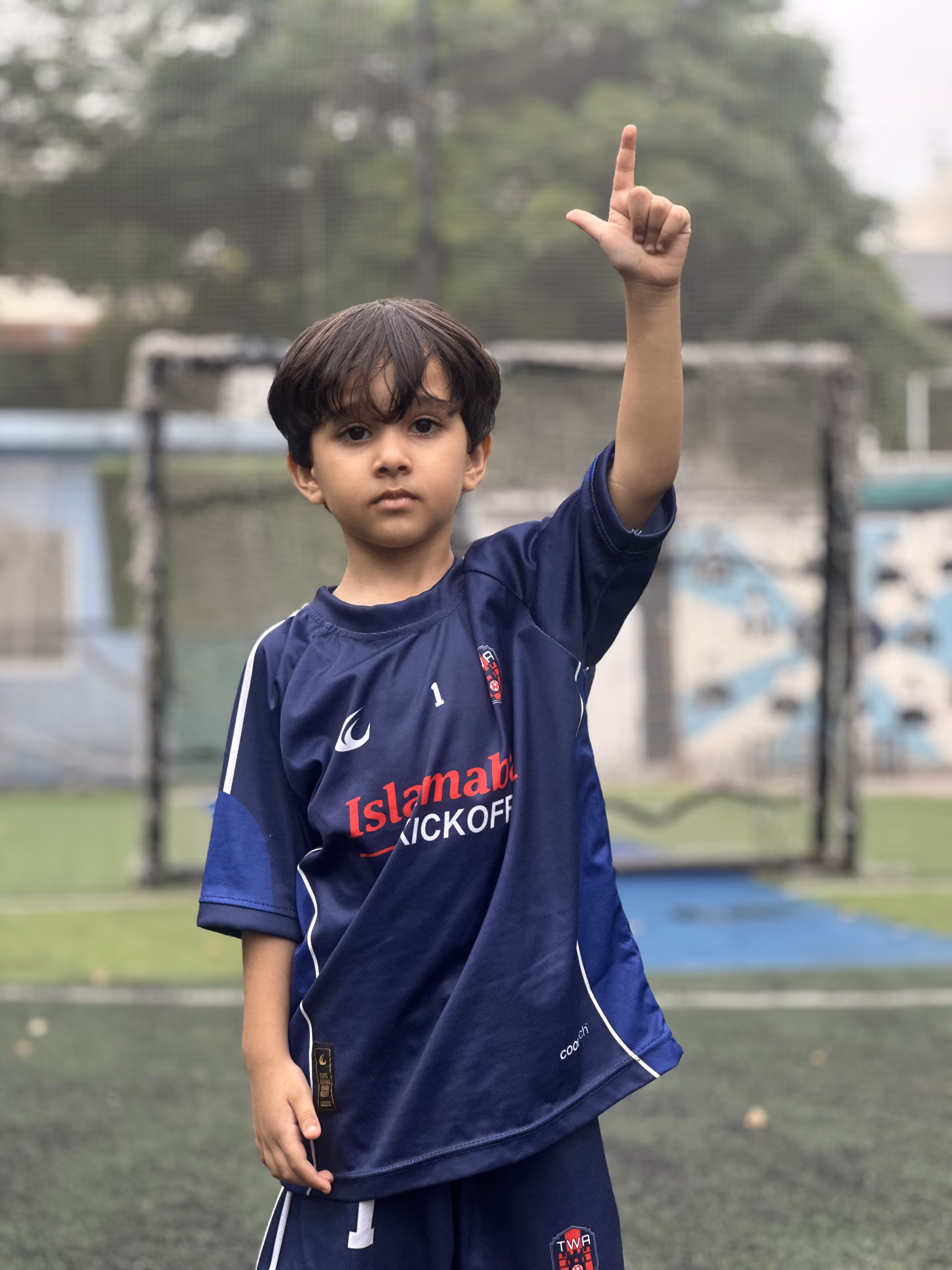 The youngest player holding one finger up to the camera