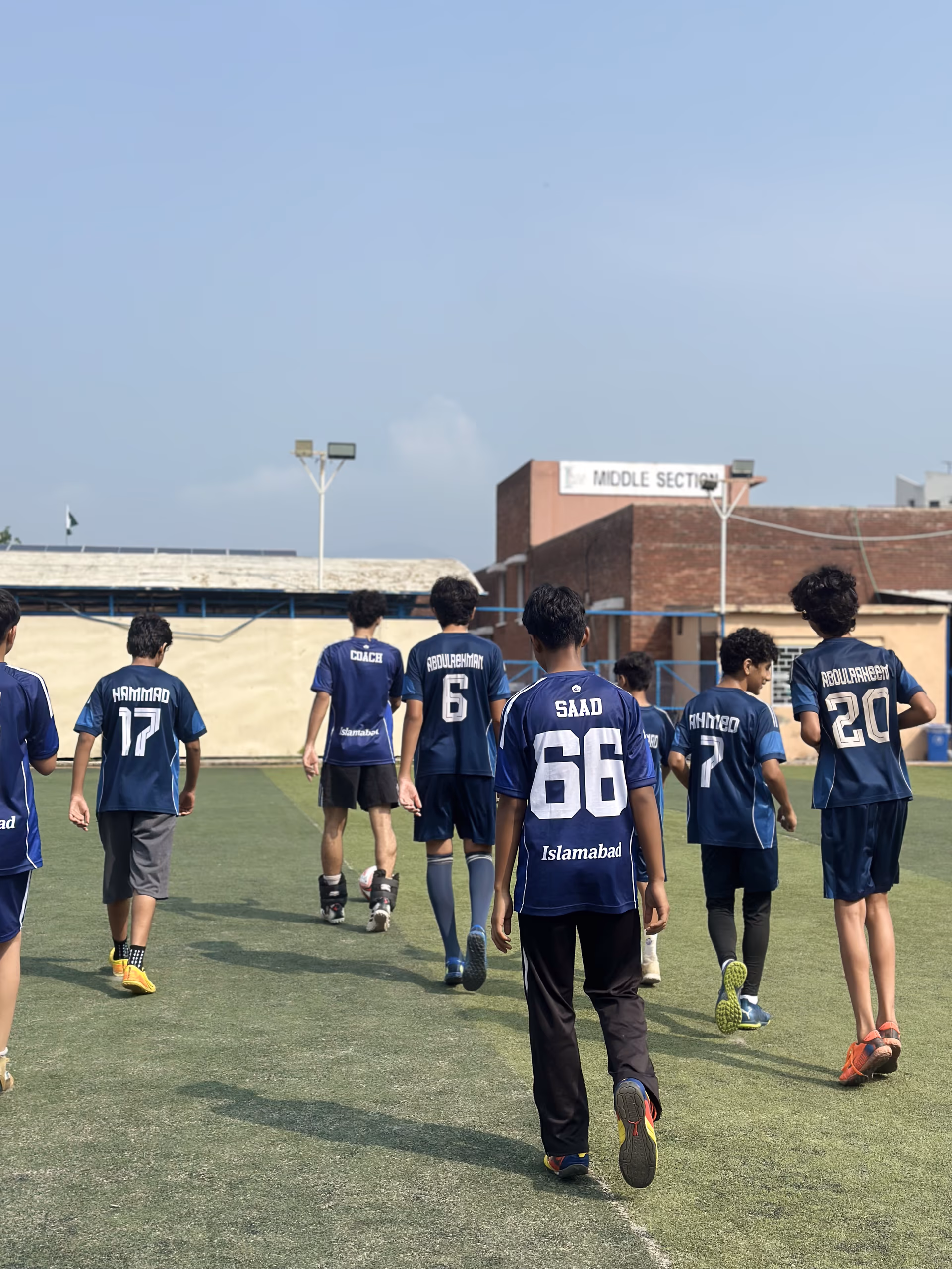 The squad walking away across the pitch at the end of training